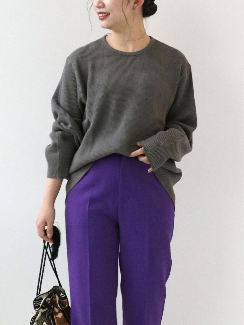 パープル系のスラックス、ブラック系のTシャツ/カットソー、オレンジ系のショルダーバッグを着用したレディースの秋コーディネートの4枚目の写真