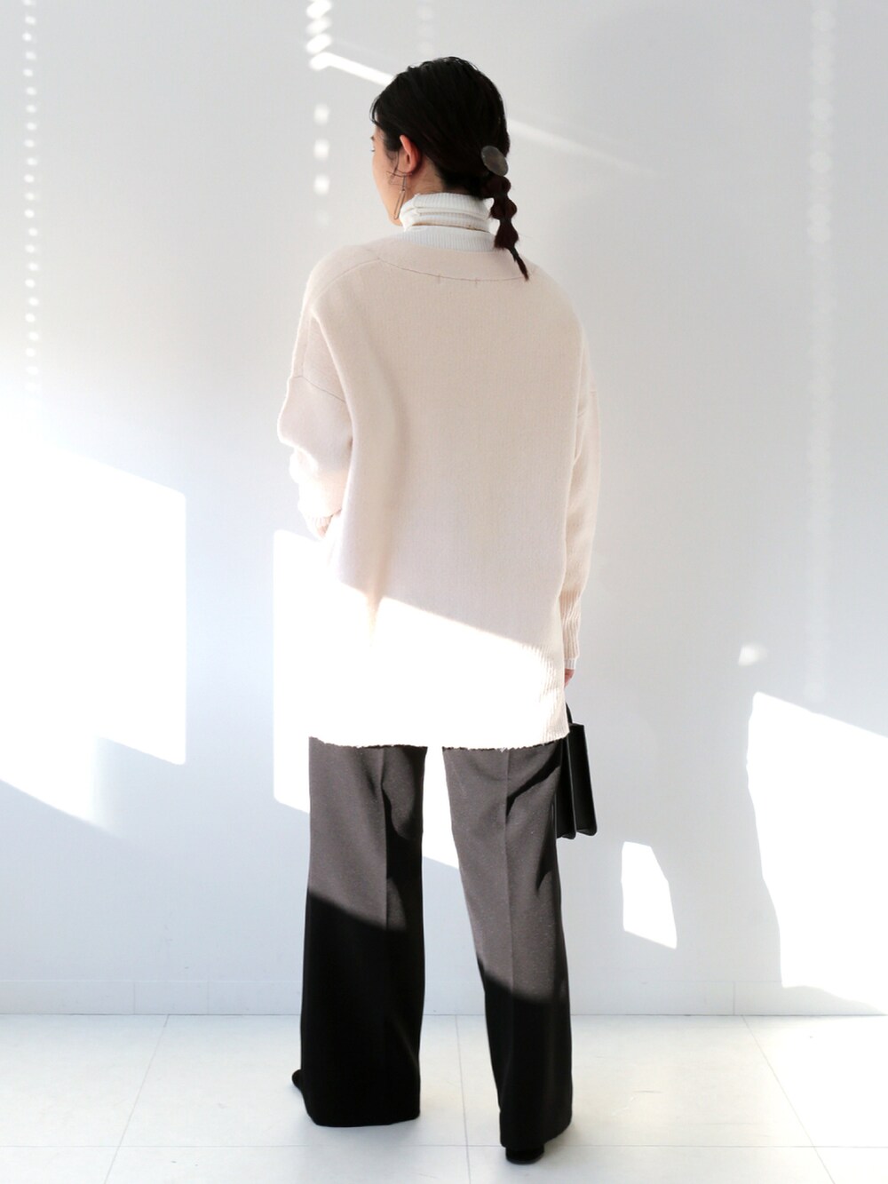 ホワイト系のニット/セーター、ホワイト系のニット/セーター、ブラック系のスラックスを着用したレディースの冬コーディネートの3枚目の写真