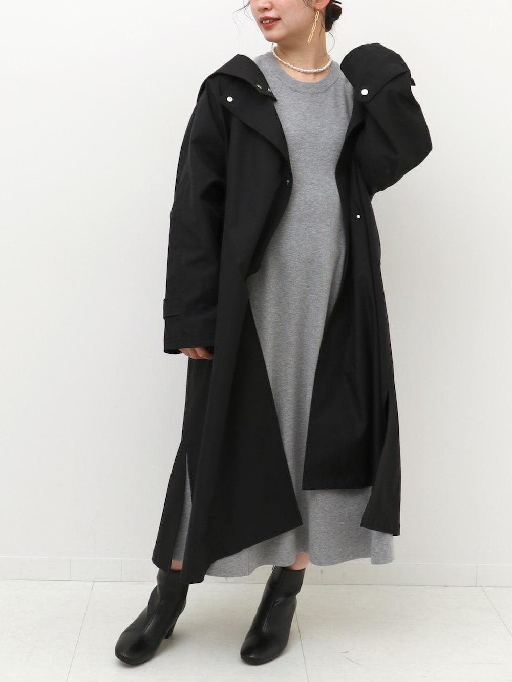 グレー系のワンピース、ブラック系のノーカラーコートを着用したレディースの冬コーディネートの3枚目の写真