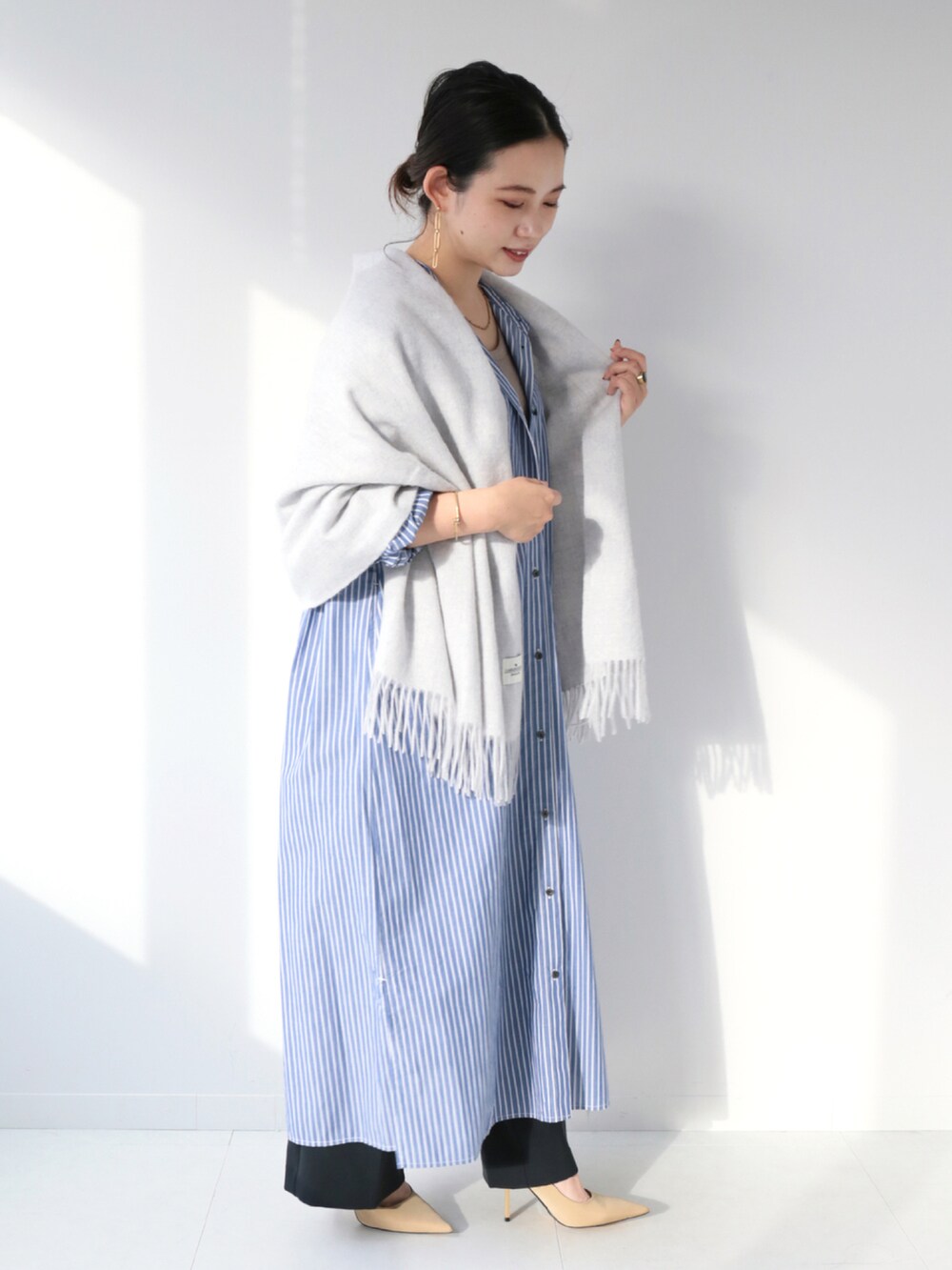 ブルー系のワンピース、ブラック系のスラックス、グレー系のマフラーを着用したレディースの冬コーディネートの2枚目の写真