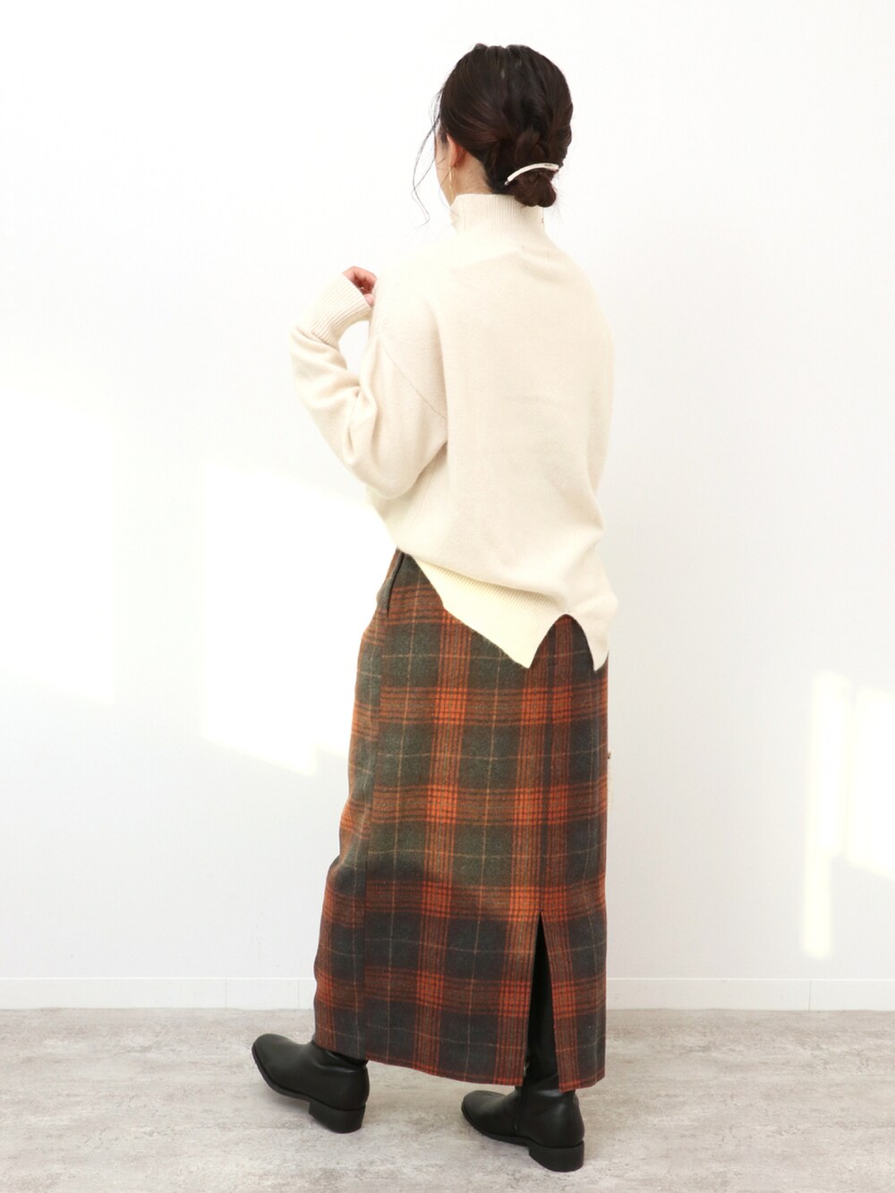 ホワイト系のショルダーバッグ、ブラウン系のスカート、ホワイト系のニット/セーターを着用したレディースの冬コーディネートの3枚目の写真