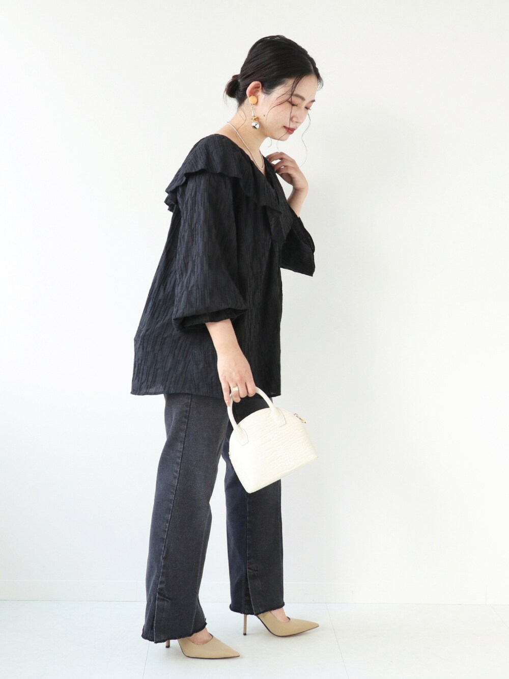 ブラック系のシャツ/ブラウス、ブラック系のデニムパンツ、ホワイト系のショルダーバッグを着用したレディースの秋コーディネートの2枚目の写真