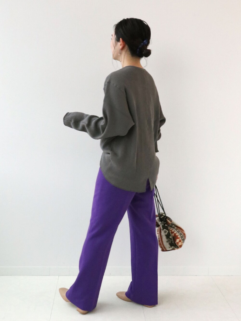 パープル系のスラックス、ブラック系のTシャツ/カットソー、オレンジ系のショルダーバッグを着用したレディースの秋コーディネートの2枚目の写真