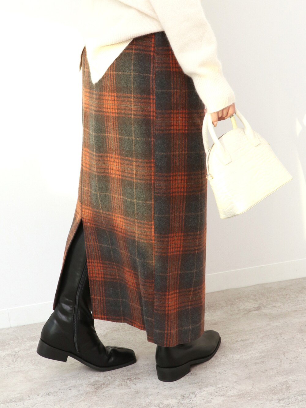 ホワイト系のショルダーバッグ、ブラウン系のスカート、ホワイト系のニット/セーターを着用したレディースの冬コーディネートの4枚目の写真