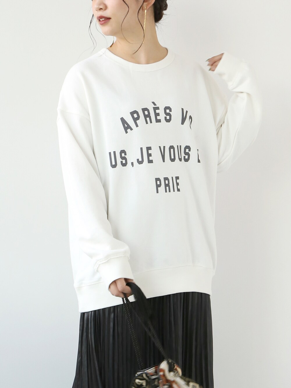 ホワイト系のTシャツ/カットソー、ブラック系のスカート、ベージュ系のバッグを着用したレディースの秋コーディネートの3枚目の写真