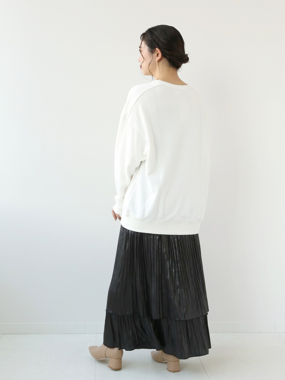 ホワイト系のTシャツ/カットソー、ブラック系のスカート、ベージュ系のバッグを着用したレディースの秋コーディネートの2枚目の写真