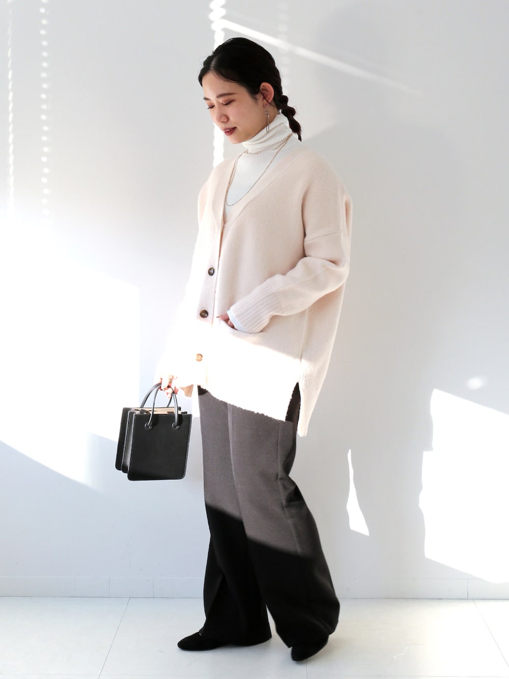 ホワイト系のニット/セーター、ホワイト系のニット/セーター、ブラック系のスラックスを着用したレディースの冬コーディネートの2枚目の写真