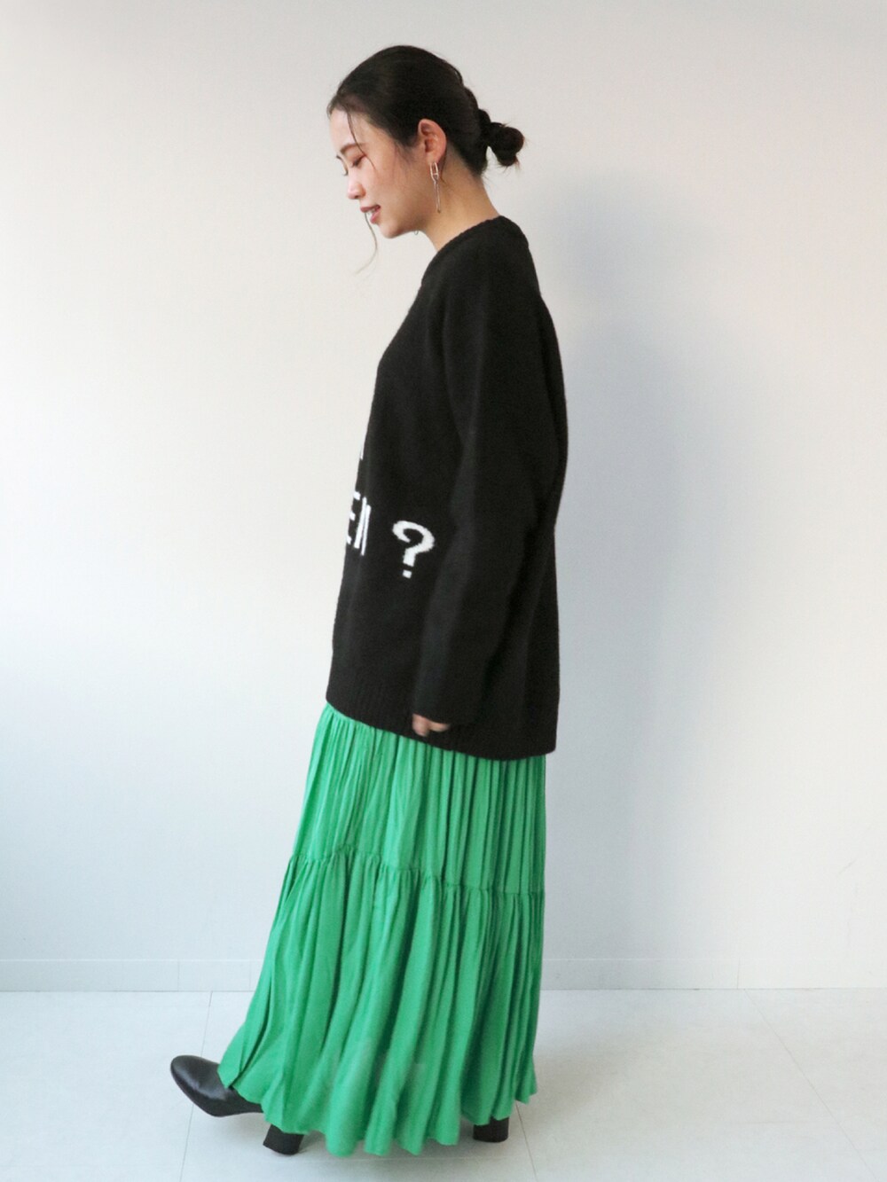 ブラック系のニット/セーター、グリーン系のスカート、ブラック系のショルダーバッグを着用したレディースの冬コーディネートの3枚目の写真