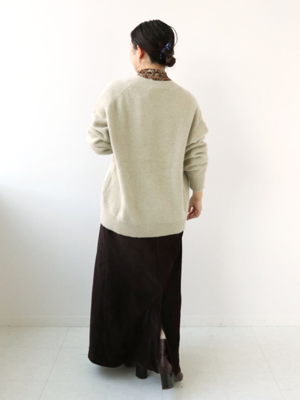 ブラウン系のTシャツ/カットソー、ベージュ系のニット/セーター、ブラウン系のスカートを着用したレディースの冬コーディネートの3枚目の写真