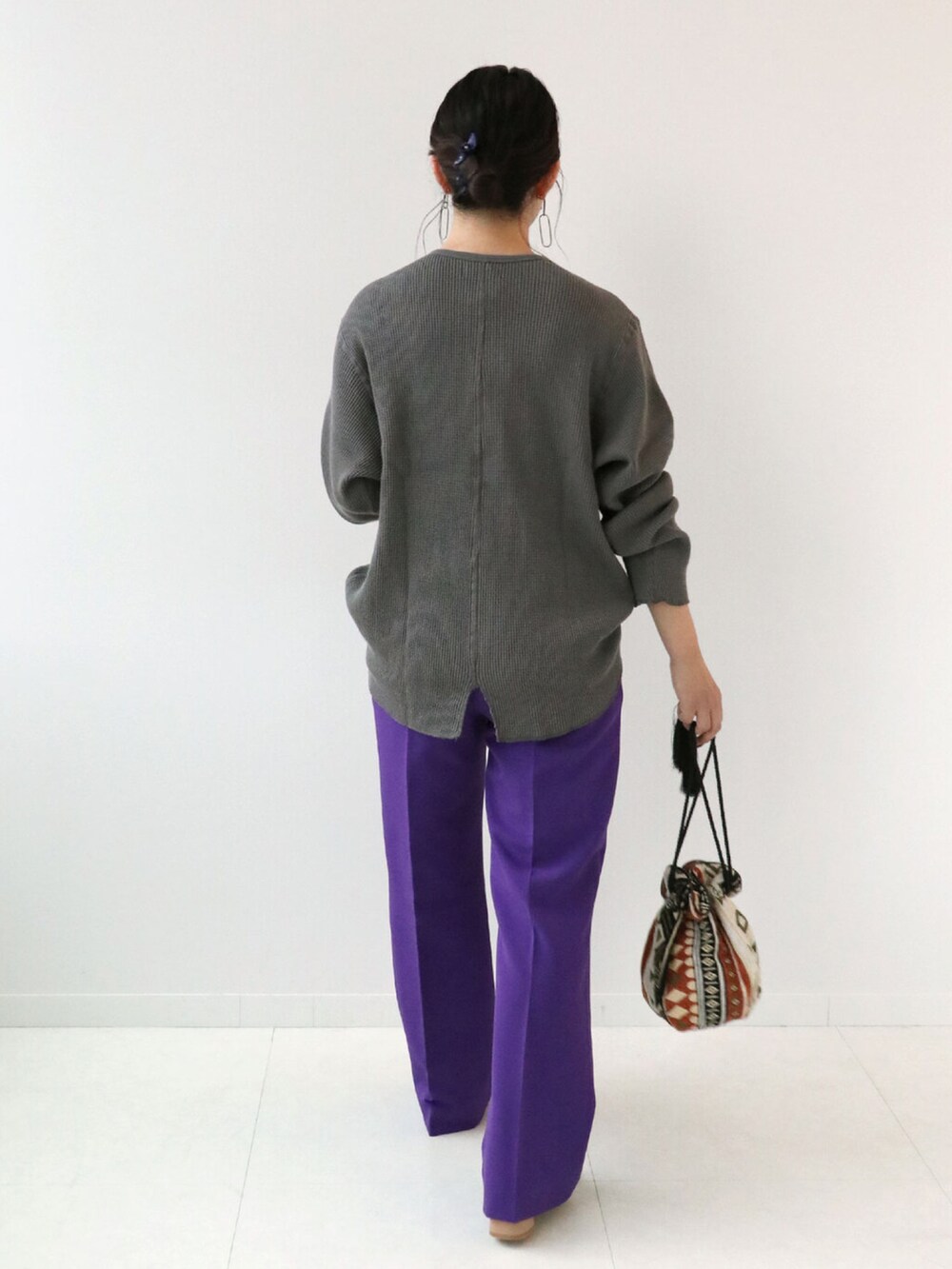 パープル系のスラックス、ブラック系のTシャツ/カットソー、オレンジ系のショルダーバッグを着用したレディースの秋コーディネートの3枚目の写真