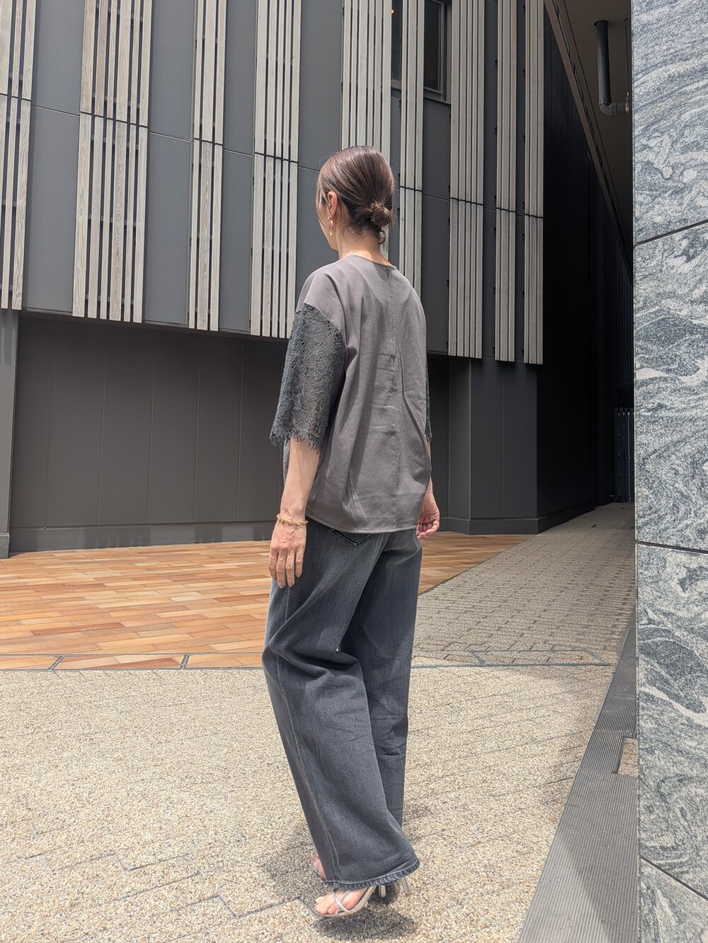 グリーン系のTシャツ/カットソー、ブラック系のデニムパンツを着用したレディースの夏コーディネートの3枚目の写真