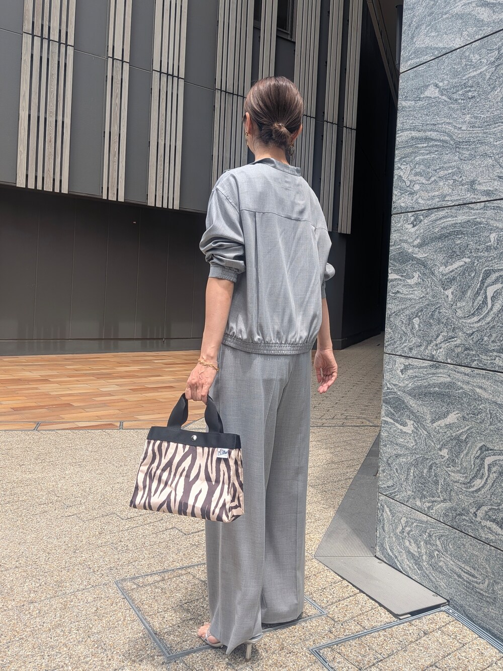 グレー系のその他パンツ、ブラック系のトートバッグを着用したレディースの夏コーディネートの3枚目の写真