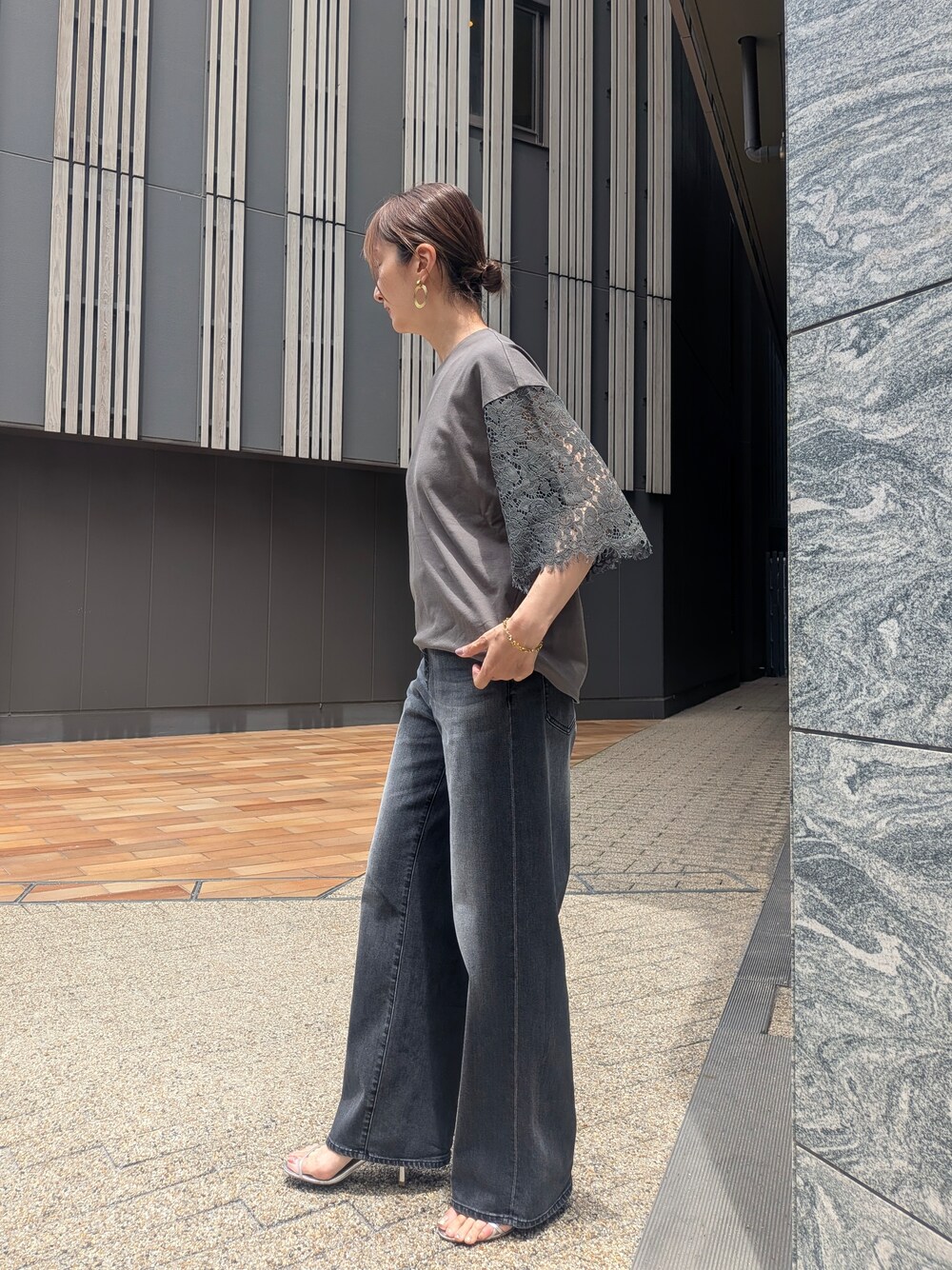 グリーン系のTシャツ/カットソー、ブラック系のデニムパンツを着用したレディースの夏コーディネートの4枚目の写真