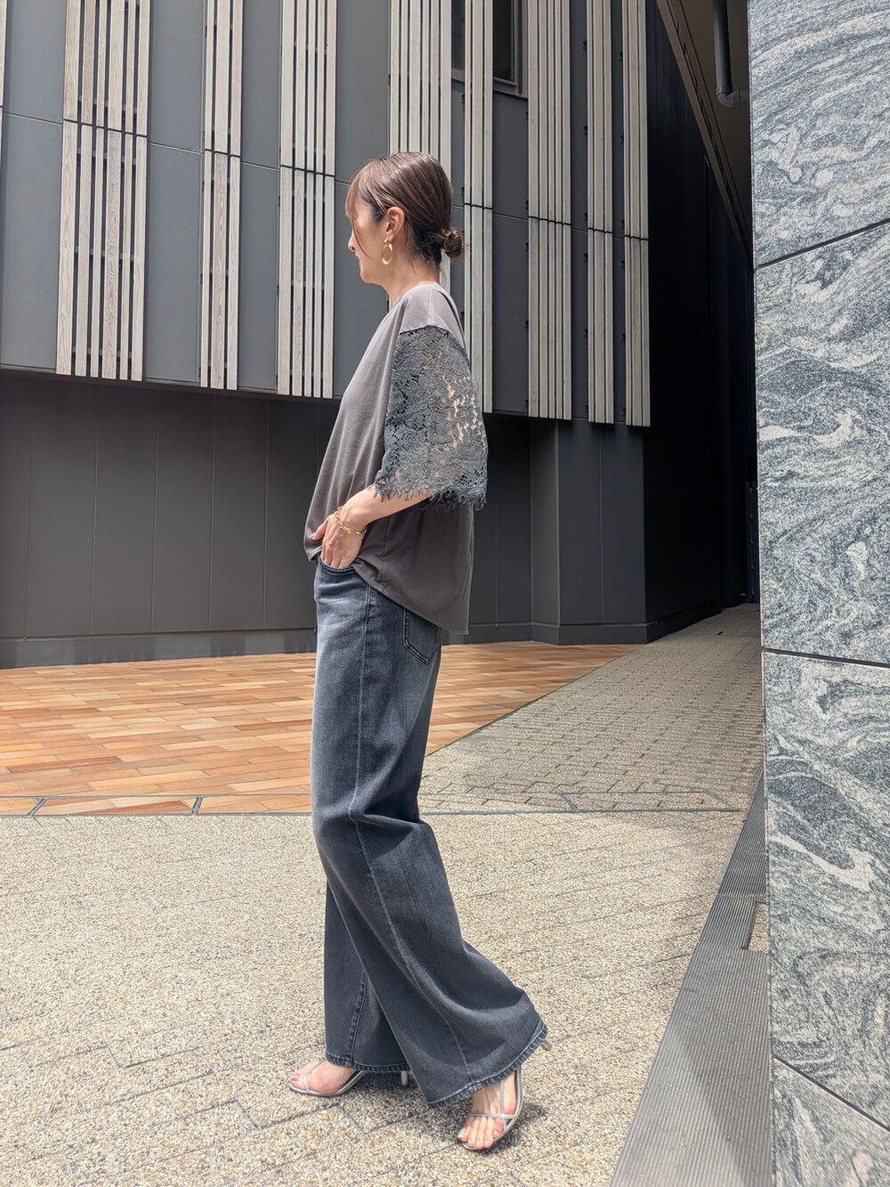 グリーン系のTシャツ/カットソー、ブラック系のデニムパンツを着用したレディースの夏コーディネートの2枚目の写真