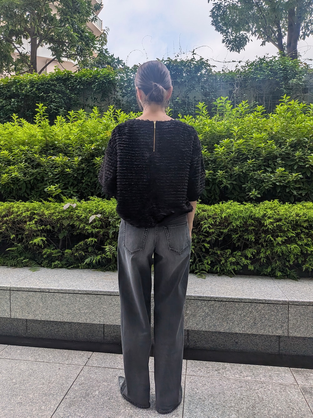 ブラック系のデニムパンツを着用したレディースの夏コーディネートの2枚目の写真