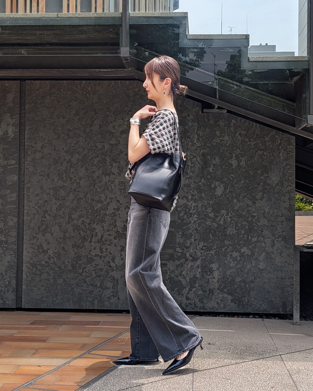 ブラック系のシャツ/ブラウス、ブラック系のデニムパンツ、ブラック系のショルダーバッグを着用したレディースの夏コーディネートの2枚目の写真