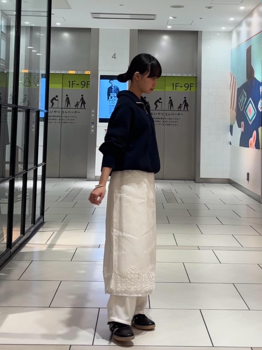 ブルー系のスウェット、ホワイト系のスカート、ホワイト系のその他パンツを着用したレディースの冬コーディネートの2枚目の写真