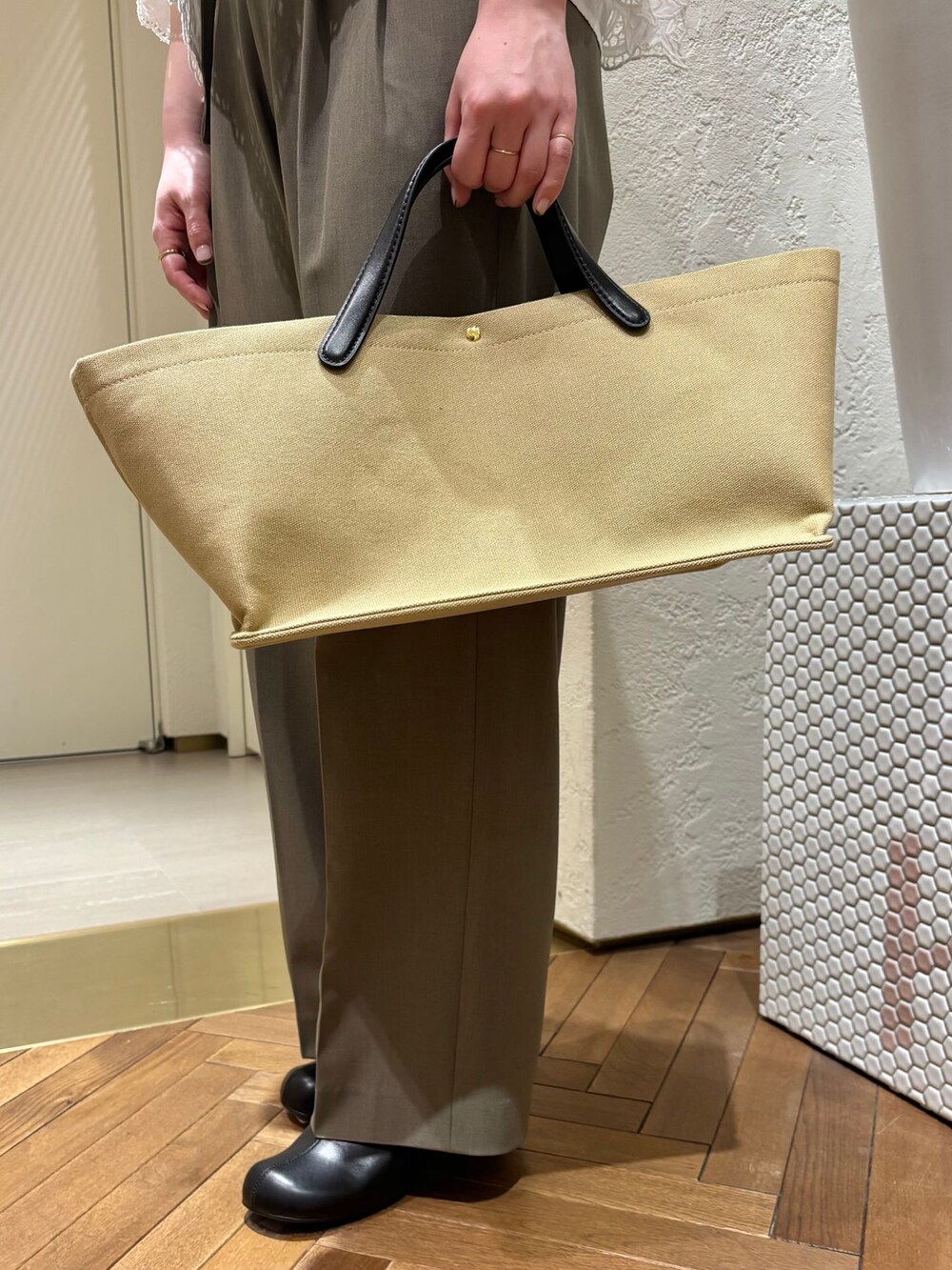 グリーン系のスラックス、ホワイト系のシャツ/ブラウス、ベージュ系のトートバッグを着用したレディースの春コーディネートの7枚目の写真