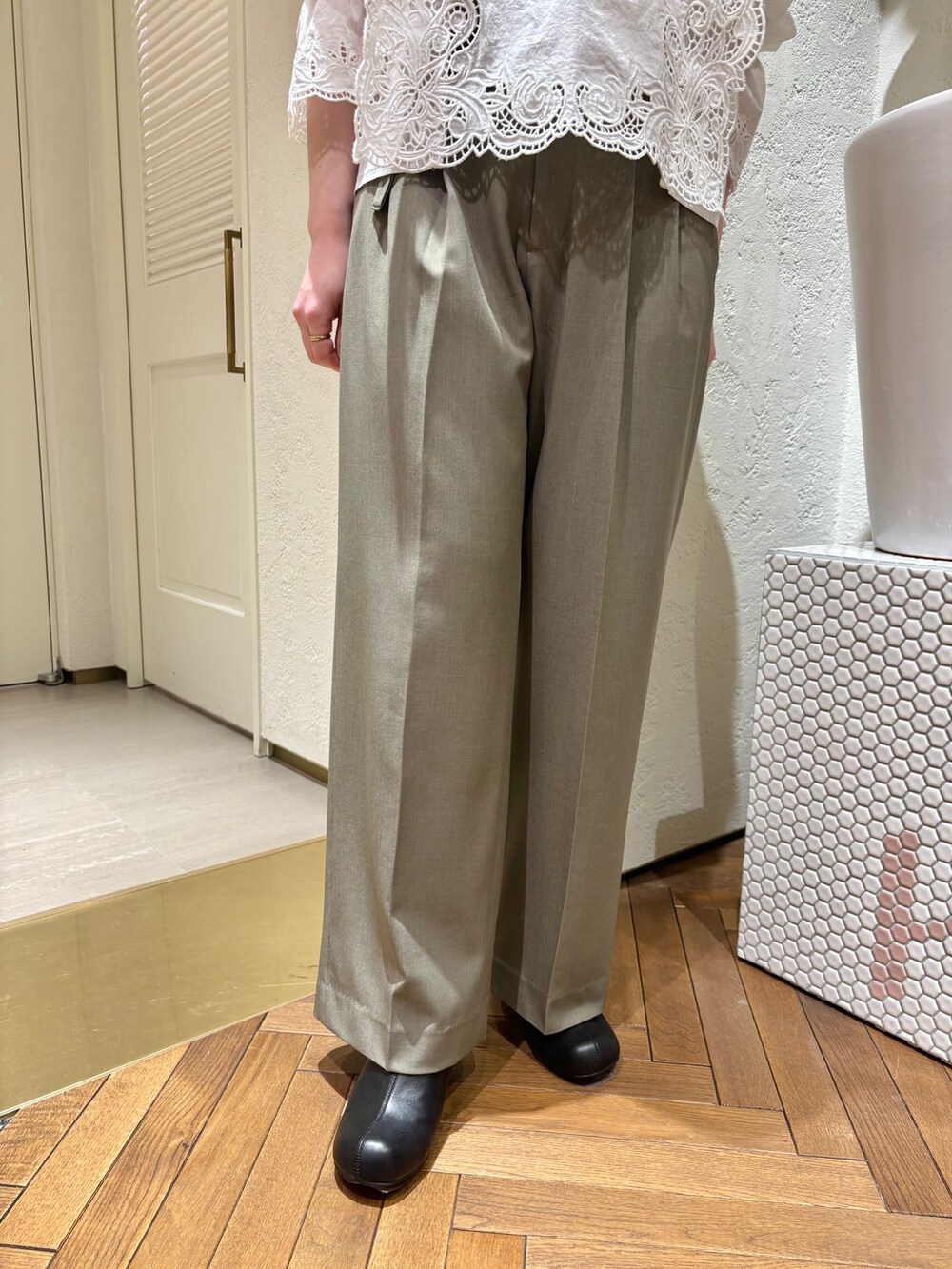 グリーン系のスラックス、ホワイト系のシャツ/ブラウス、ベージュ系のトートバッグを着用したレディースの春コーディネートの5枚目の写真