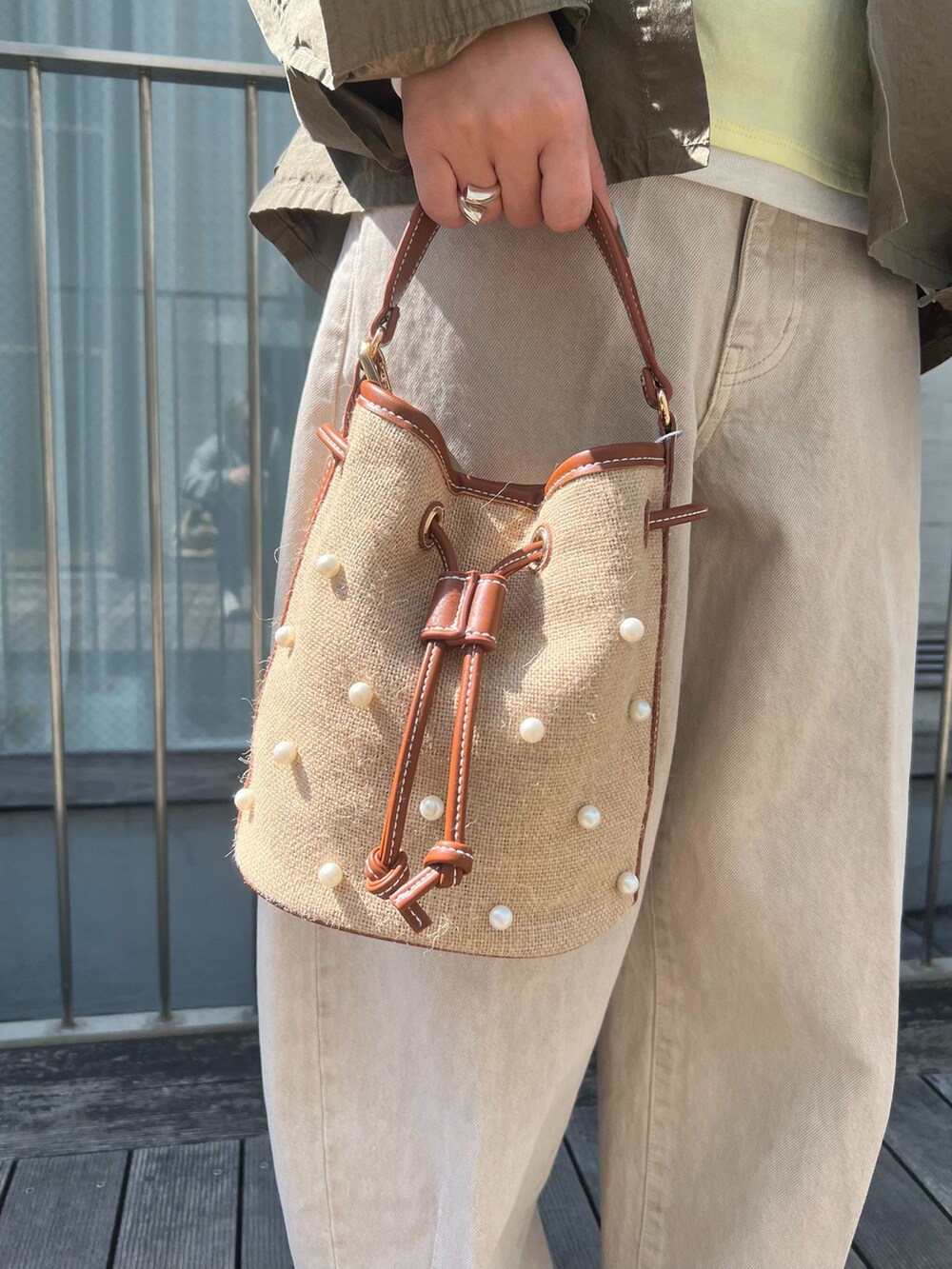 ベージュ系のデニムパンツ、グリーン系のシャツ/ブラウス、イエロー系のTシャツ/カットソーを着用したレディースの春コーディネートの6枚目の写真