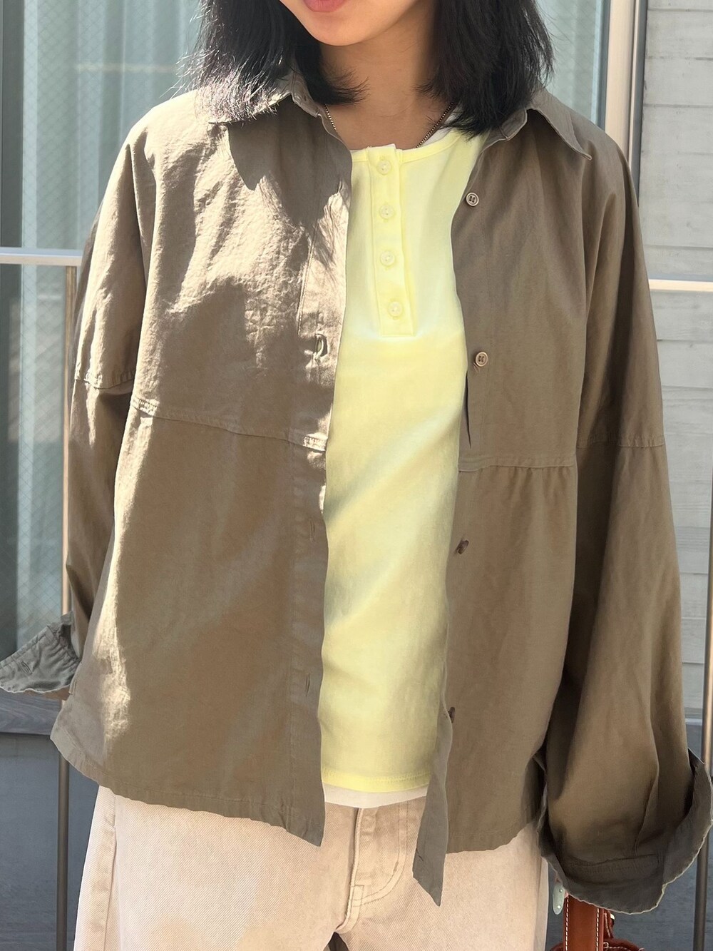 ベージュ系のデニムパンツ、グリーン系のシャツ/ブラウス、イエロー系のTシャツ/カットソーを着用したレディースの春コーディネートの4枚目の写真