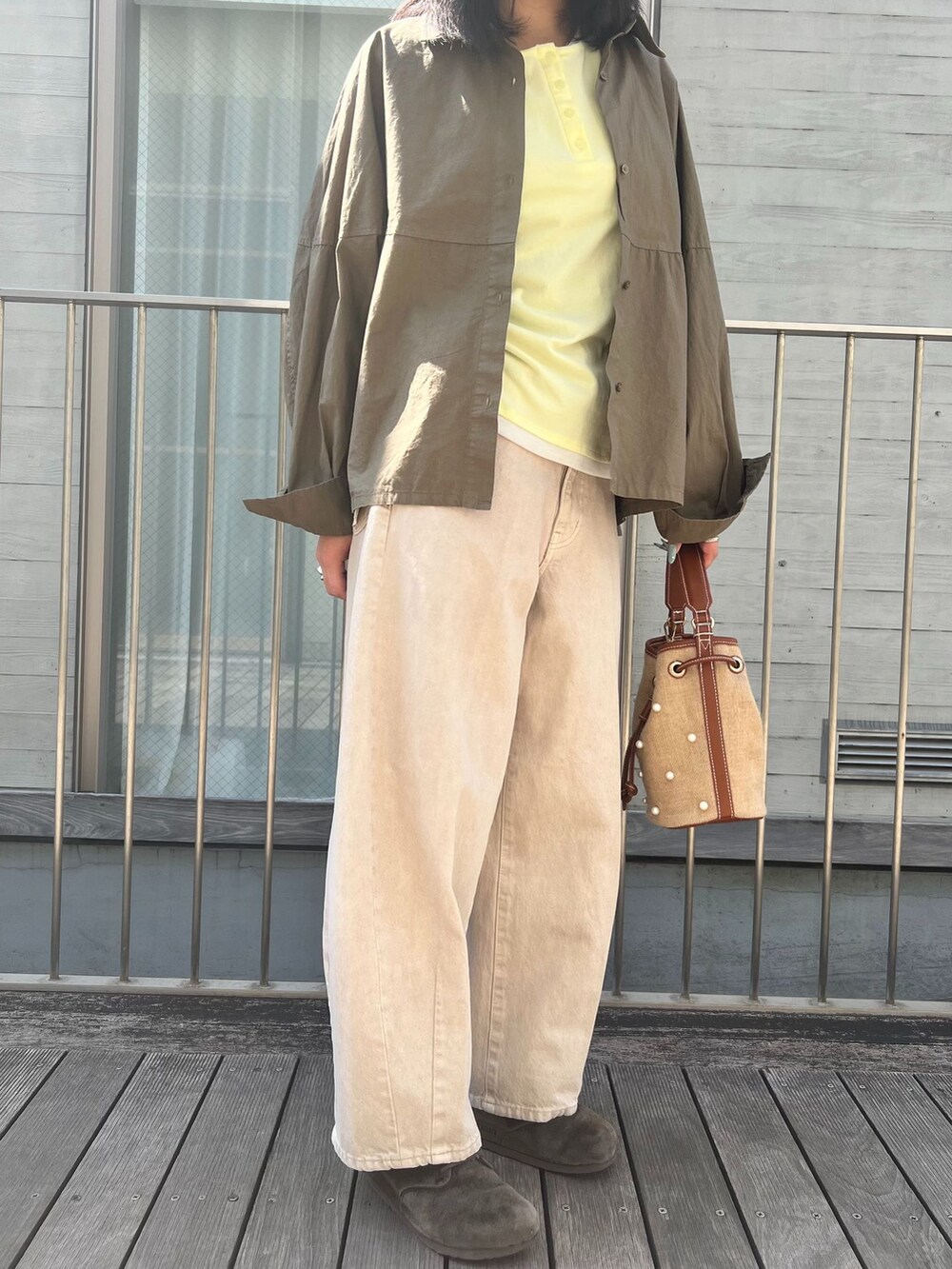ベージュ系のデニムパンツ、グリーン系のシャツ/ブラウス、イエロー系のTシャツ/カットソーを着用したレディースの春コーディネートの5枚目の写真