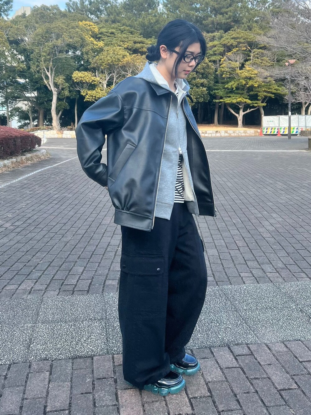 ブラック系のTシャツ/カットソー、ブラック系のカーゴパンツ、グレー系のパーカーを着用したレディースの冬コーディネートの4枚目の写真