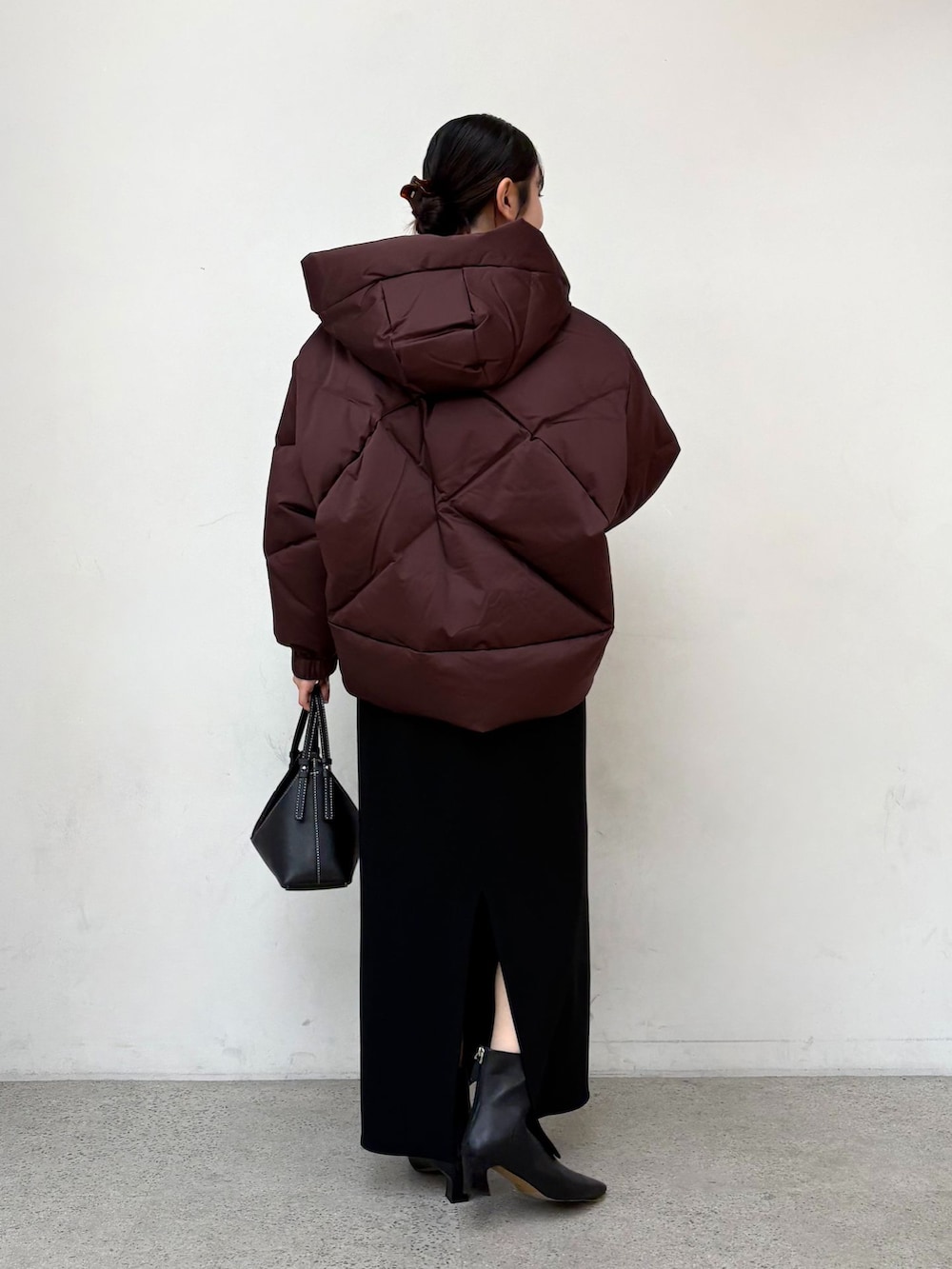 レッド系のダウンジャケット/コート、ブラック系のスカート、グレー系のニット/セーターを着用したレディースの秋コーディネートの3枚目の写真