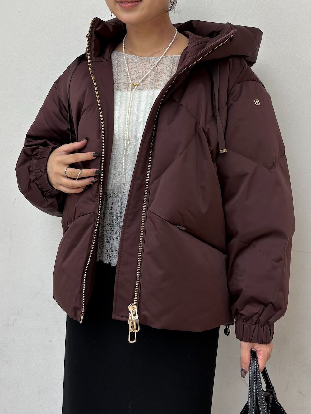 レッド系のダウンジャケット/コート、ブラック系のスカート、グレー系のニット/セーターを着用したレディースの秋コーディネートの6枚目の写真
