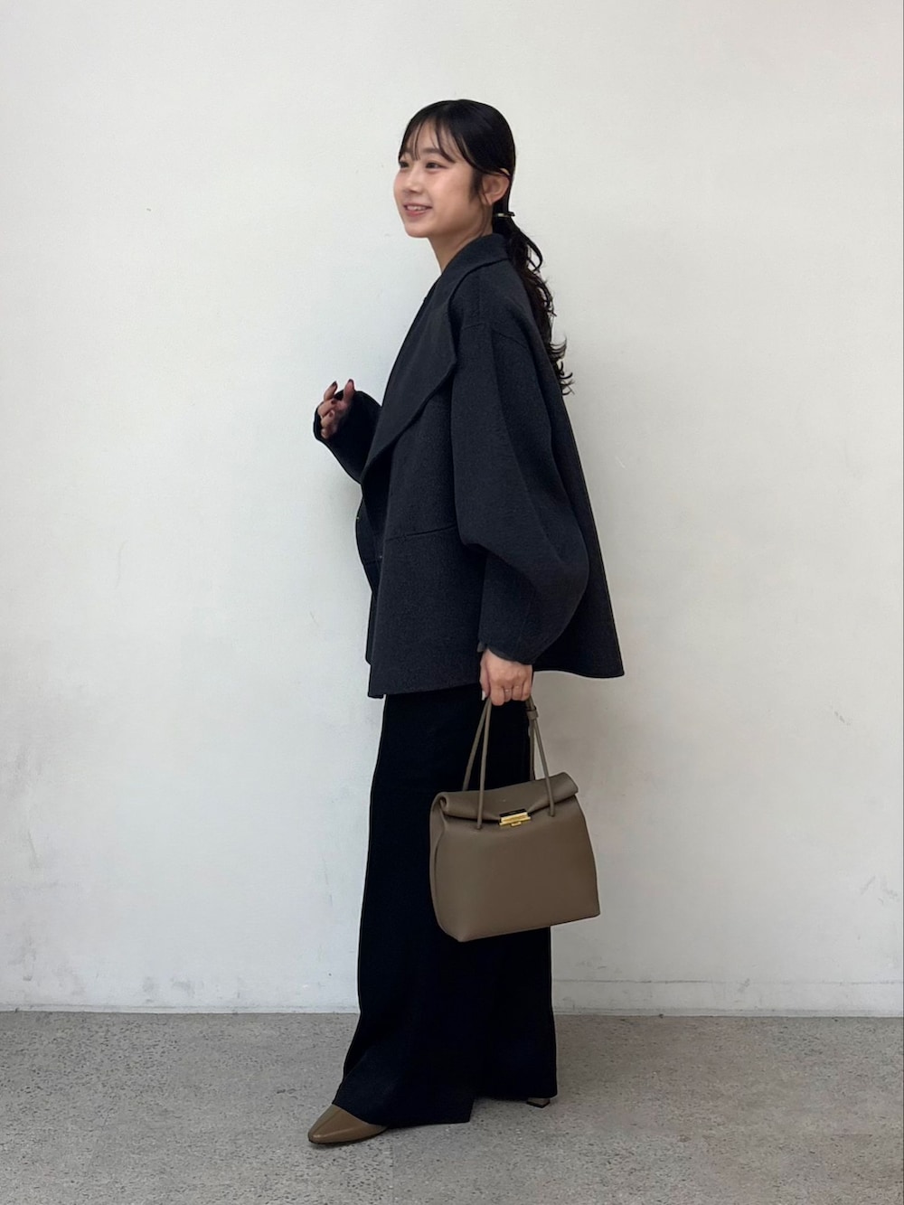 グレー系のその他アウター、ブラック系のカーゴパンツ、グレー系のニット/セーターを着用したレディースの秋コーディネートの4枚目の写真