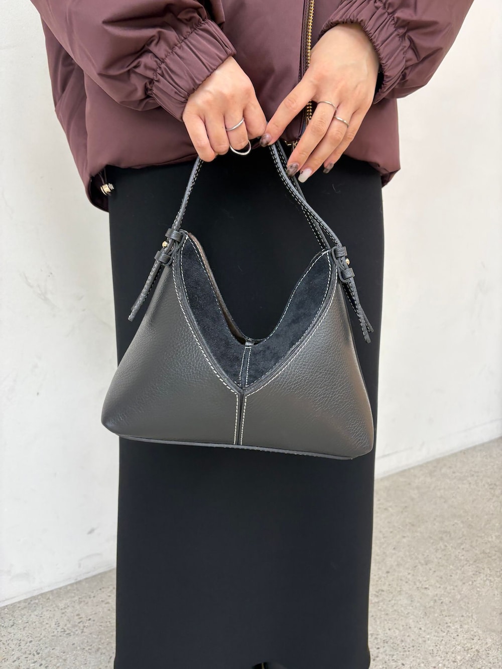 レッド系のダウンジャケット/コート、ブラック系のスカート、グレー系のニット/セーターを着用したレディースの秋コーディネートの9枚目の写真