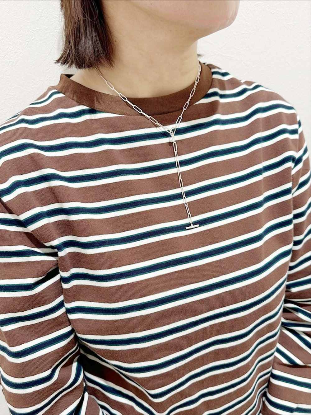 ブルー系のスラックス、その他のTシャツ/カットソー、ベージュ系のショルダーバッグを着用したレディースの春コーディネートの2枚目の写真
