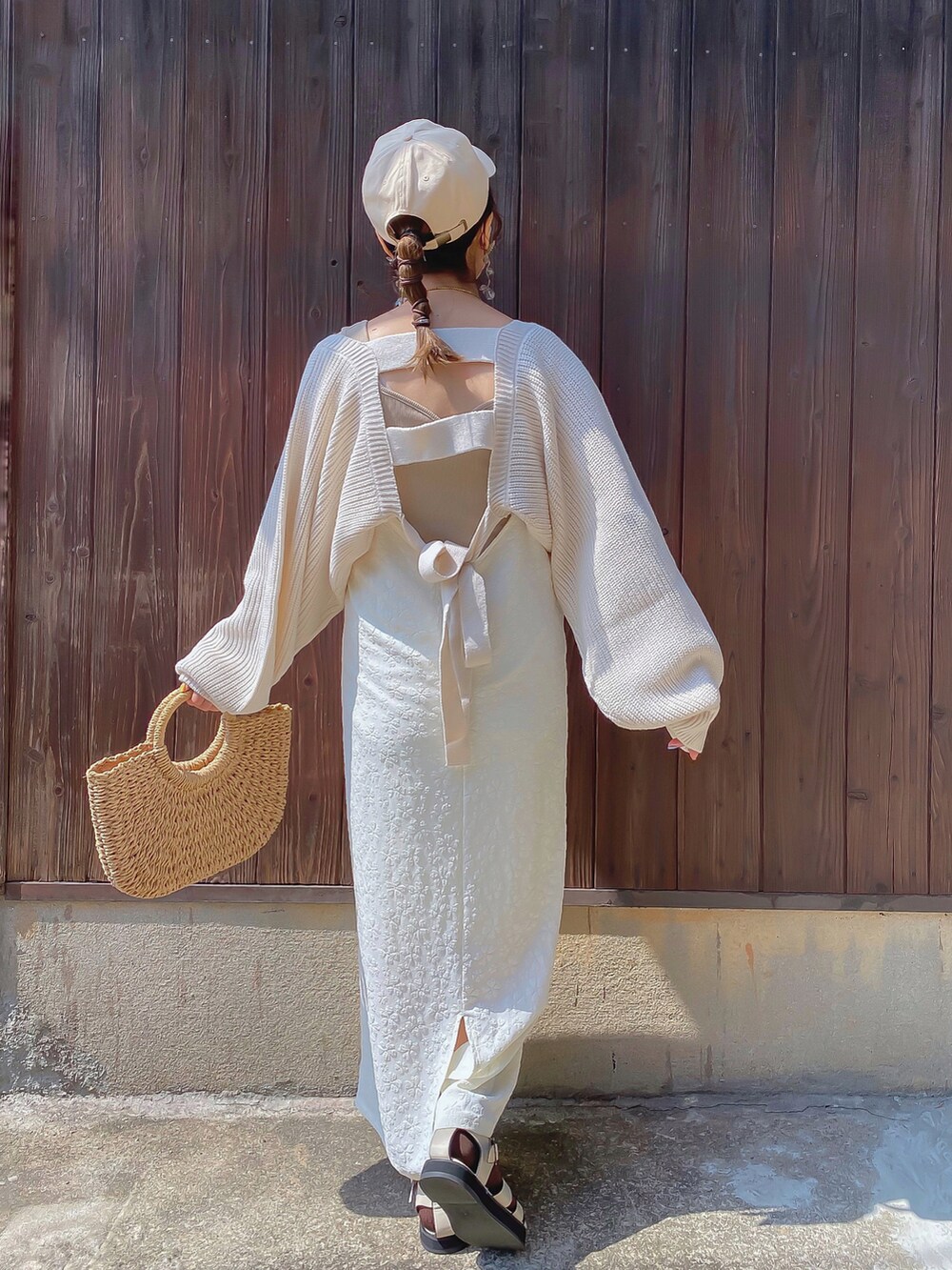 ホワイト系のワンピース、ホワイト系のカーディガン/ボレロ、ベージュ系のタンクトップを着用したレディースの春コーディネートの3枚目の写真