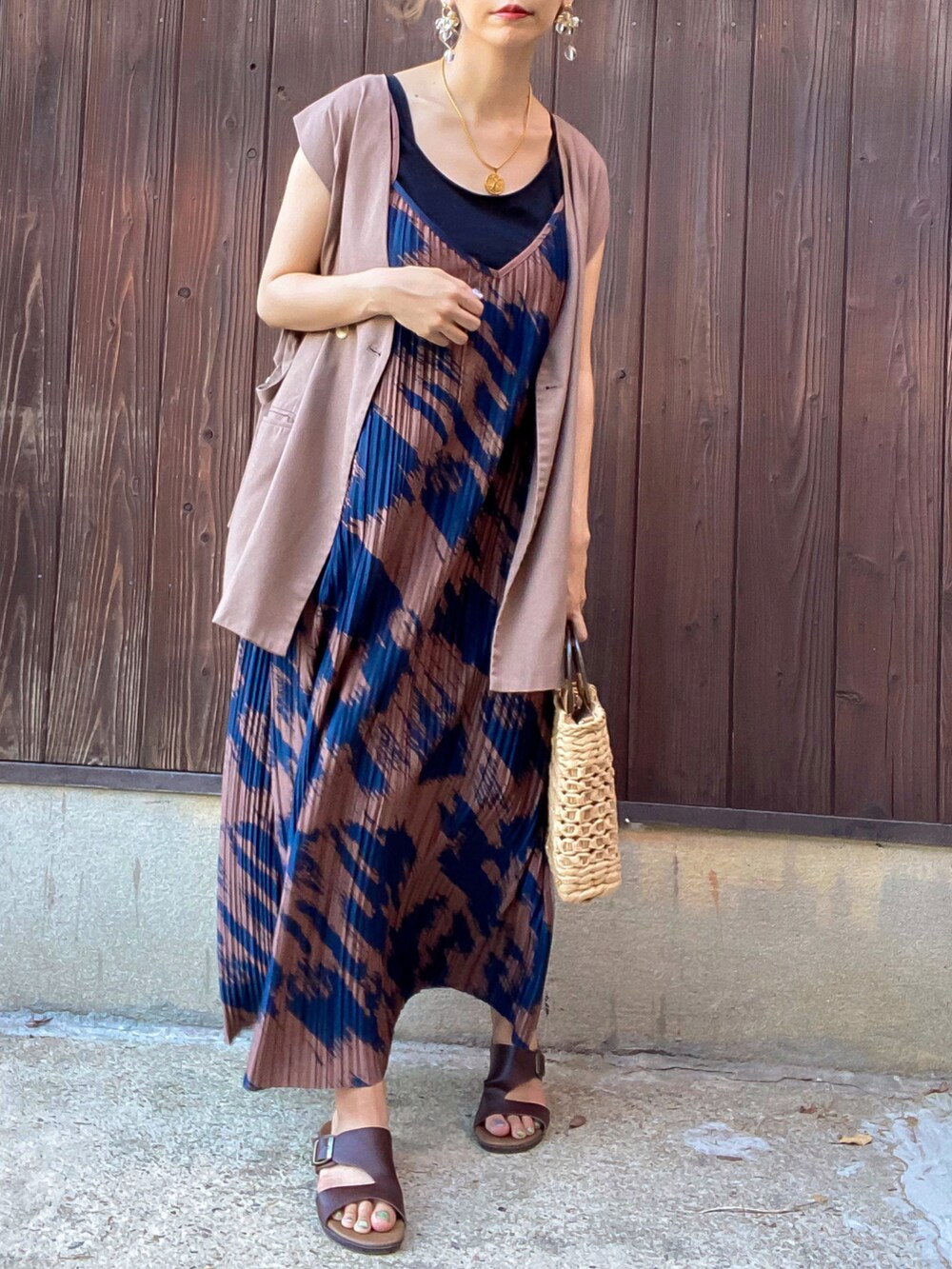 ブラウン系のワンピース、ブラウン系のベスト、ベージュ系のかごバッグを着用したレディースの夏コーディネートの2枚目の写真