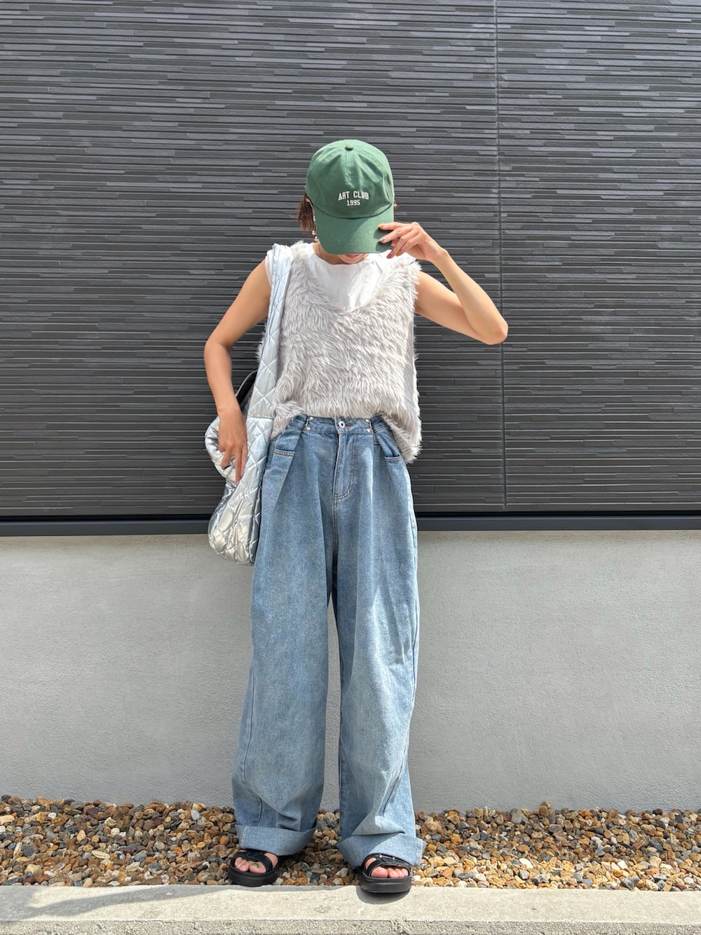 グレー系のベスト、ホワイト系のTシャツ/カットソー、ブルー系のデニムパンツを着用したレディースの秋コーディネートの2枚目の写真