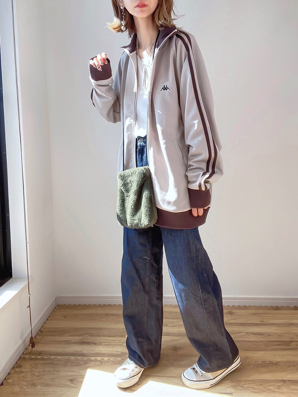 ベージュ系のジャージ、ブラック系のデニムパンツ、ベージュ系のスニーカーを着用したレディースの秋コーディネートの2枚目の写真