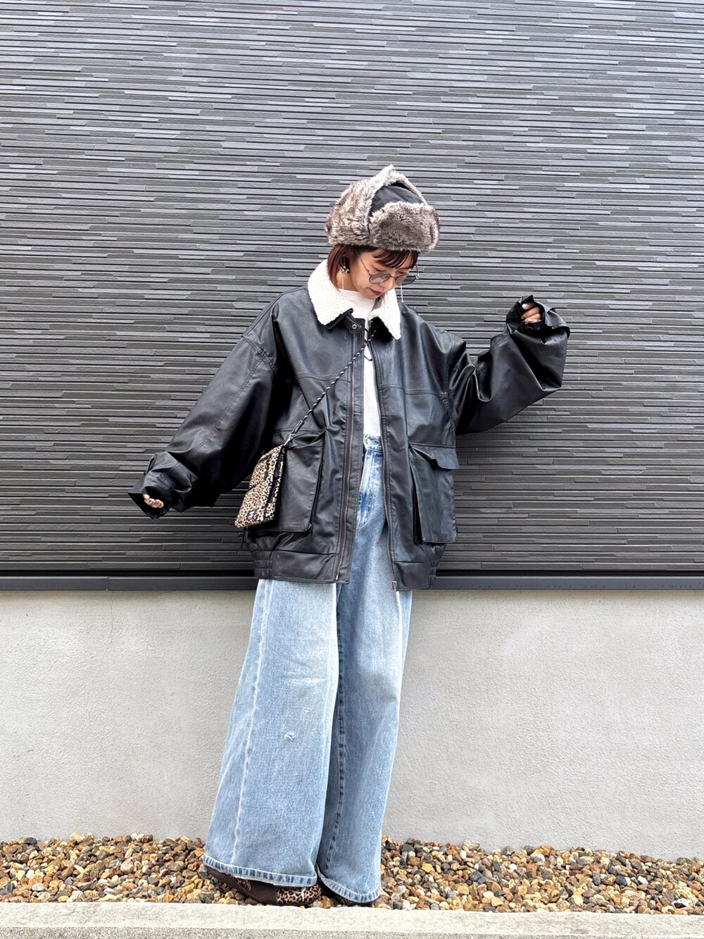 ブラック系のブルゾン、ブルー系のデニムパンツ、ブラウン系のスニーカーを着用したレディースの冬コーディネートの2枚目の写真