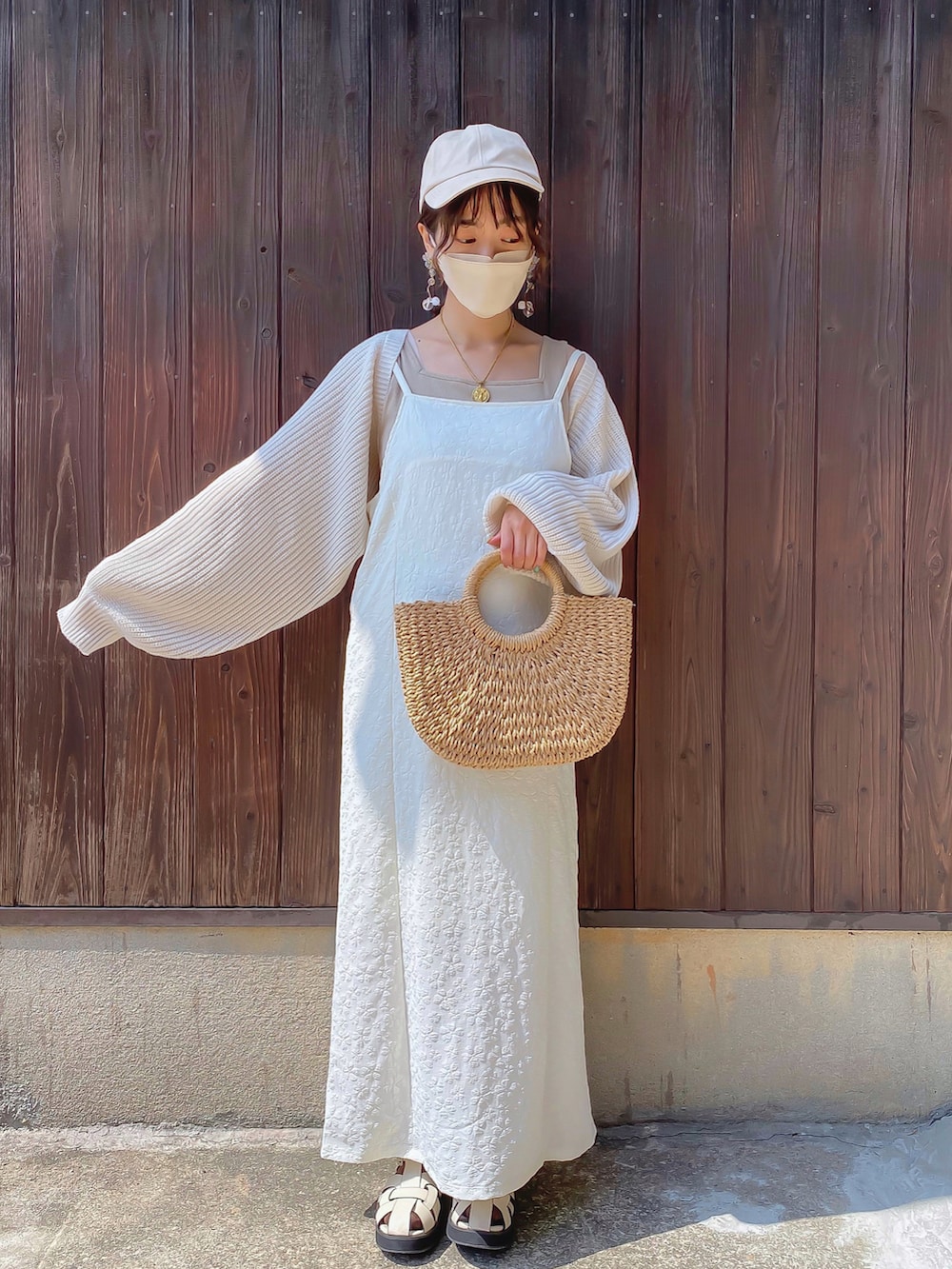 ホワイト系のワンピース、ホワイト系のカーディガン/ボレロ、ベージュ系のタンクトップを着用したレディースの春コーディネートの2枚目の写真