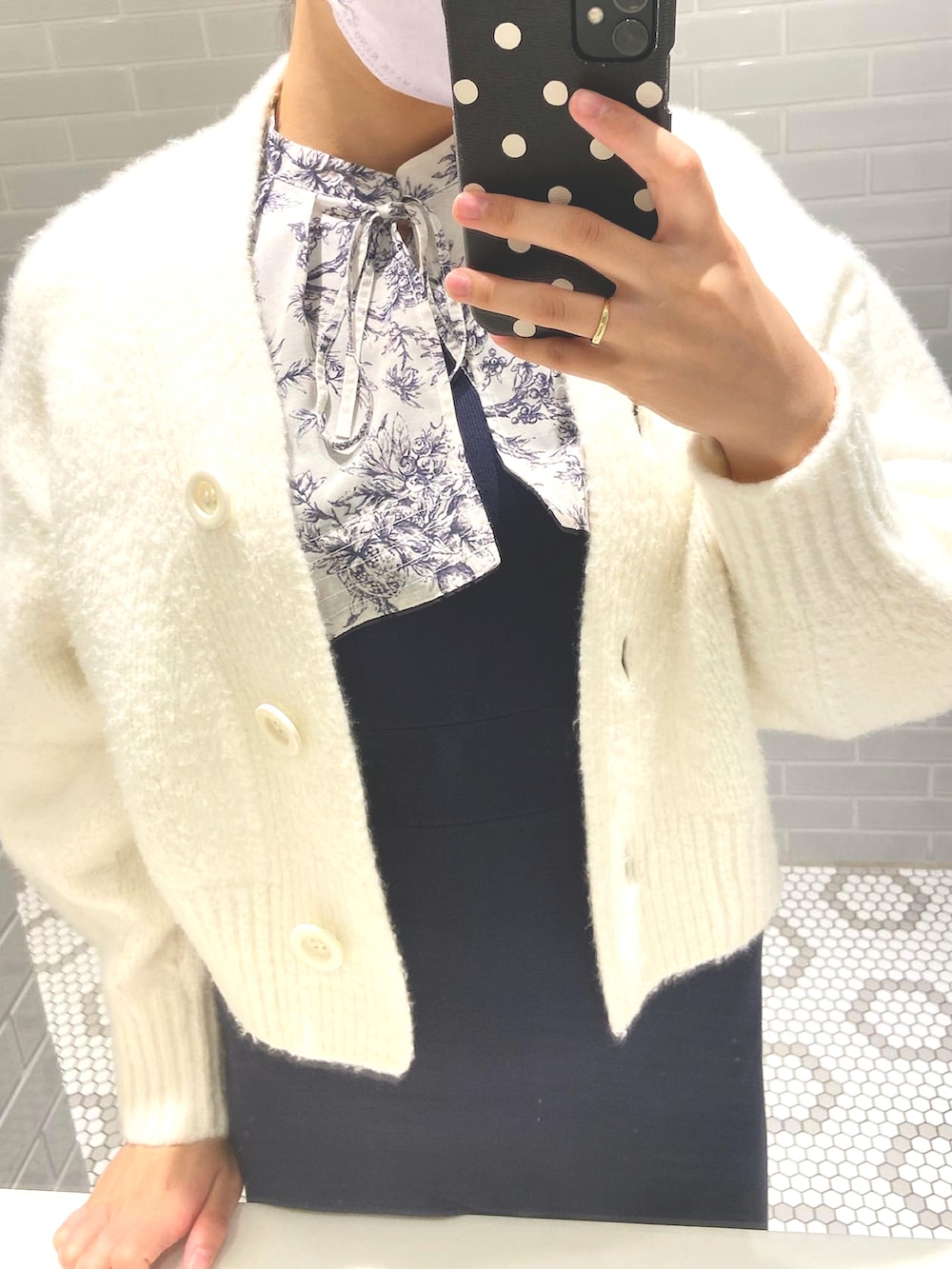 ブルー系のワンピース、ホワイト系のカーディガン/ボレロ、ブラック系のブーツを着用したレディースの秋コーディネートの2枚目の写真