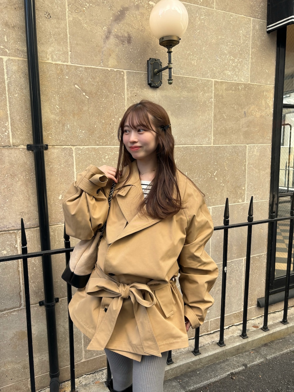 ベージュ系のトレンチコート、ベージュ系のショルダーバッグを着用したレディースの冬コーディネートの2枚目の写真