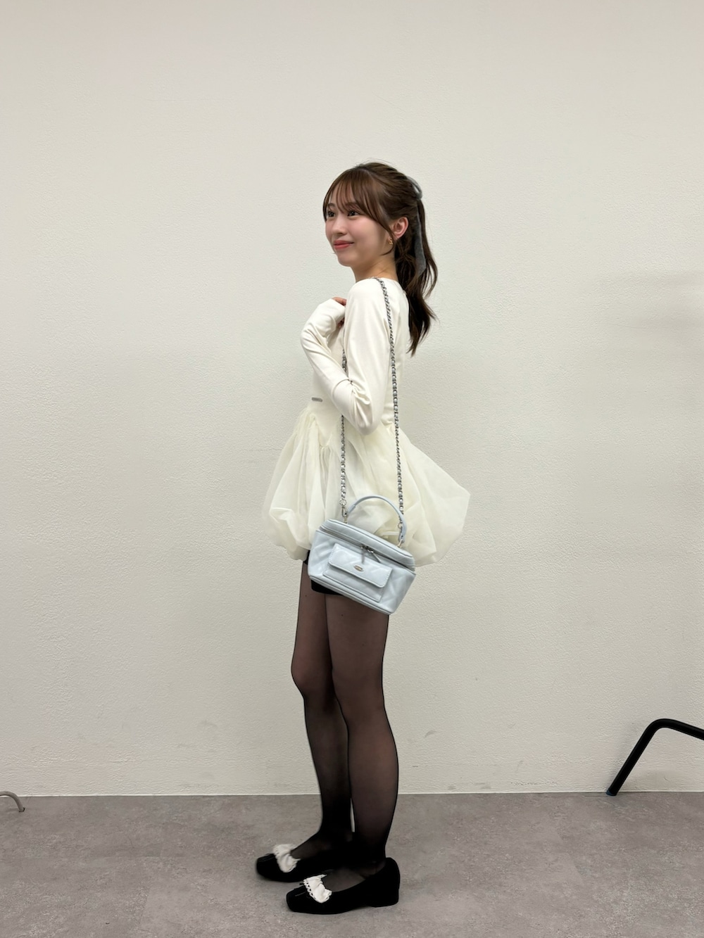 ホワイト系のTシャツ/カットソー、ブラック系のパンプス、ブルー系のショルダーバッグを着用したレディースの冬コーディネートの3枚目の写真