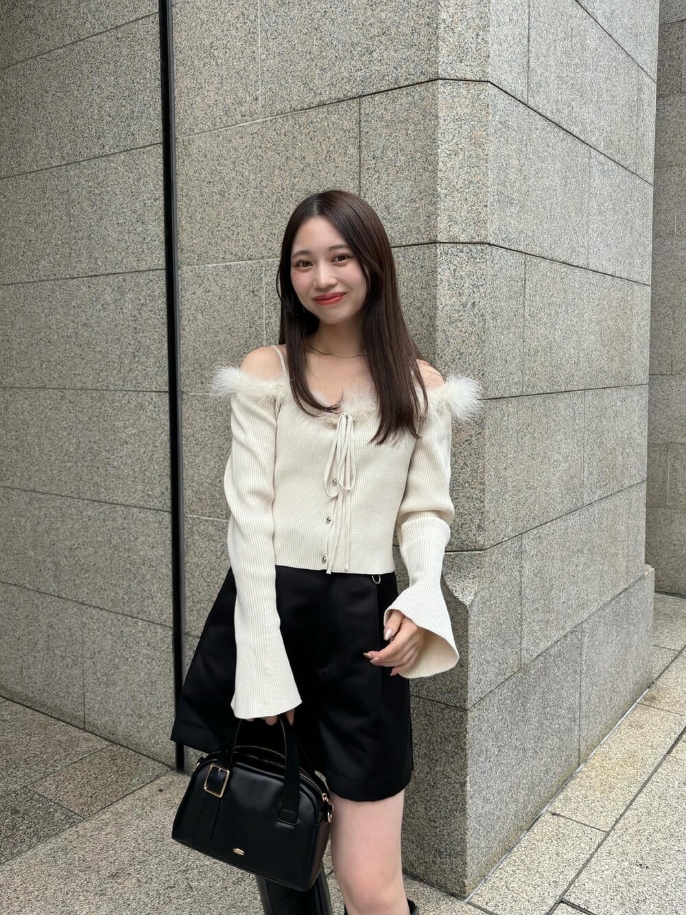 ブラック系のブーツ、ブラック系のその他パンツ、ホワイト系のニット/セーターを着用したレディースの秋コーディネートの4枚目の写真