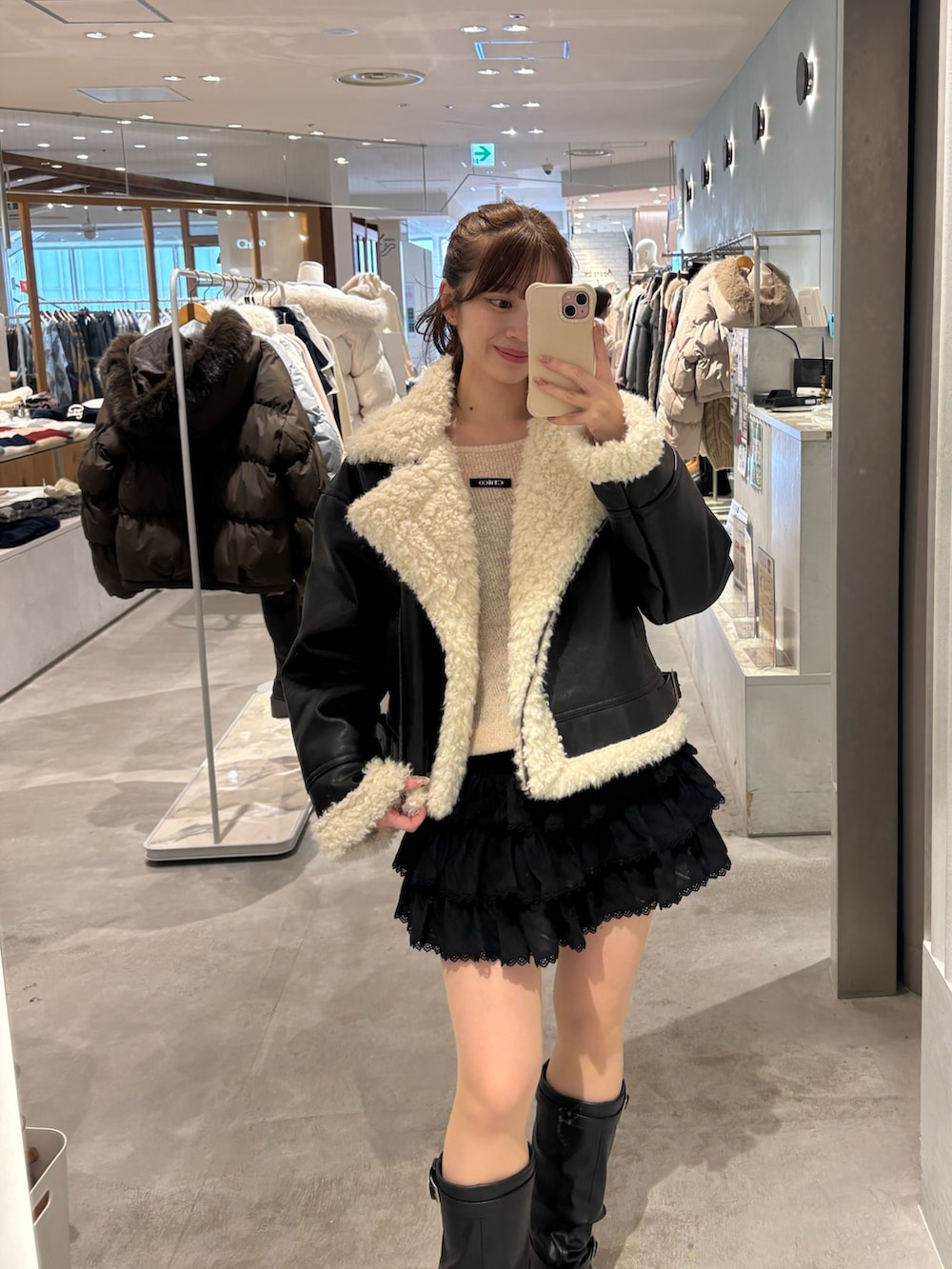 ブラック系のその他アウター、ブラック系のスカート、ブラック系のブーツを着用したレディースの冬コーディネートの2枚目の写真