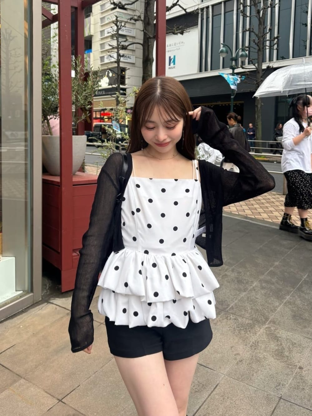 ホワイト系のシャツ/ブラウス、ブラック系のカーディガン/ボレロを着用したレディースの夏コーディネートの2枚目の写真