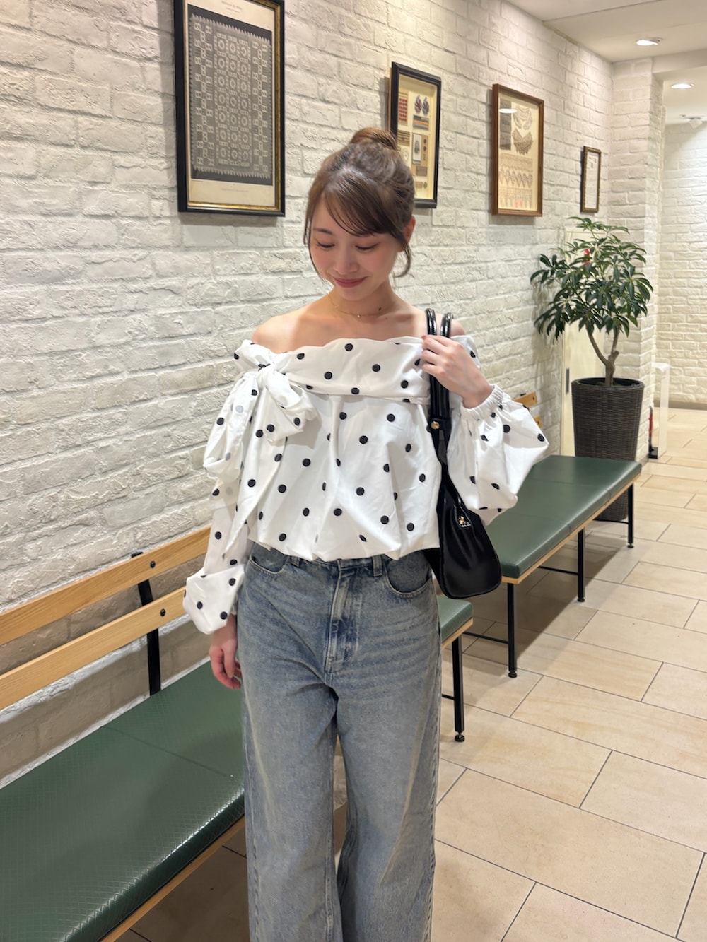ブルー系のデニムパンツ、ホワイト系のシャツ/ブラウス、ブラック系のボストンバッグを着用したレディースの夏コーディネートの3枚目の写真