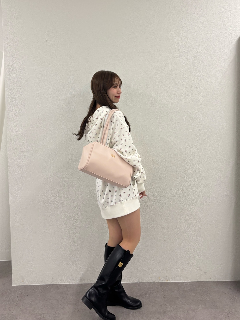 ピンク系のパーカー、ピンク系のボストンバッグを着用したレディースの冬コーディネートの3枚目の写真