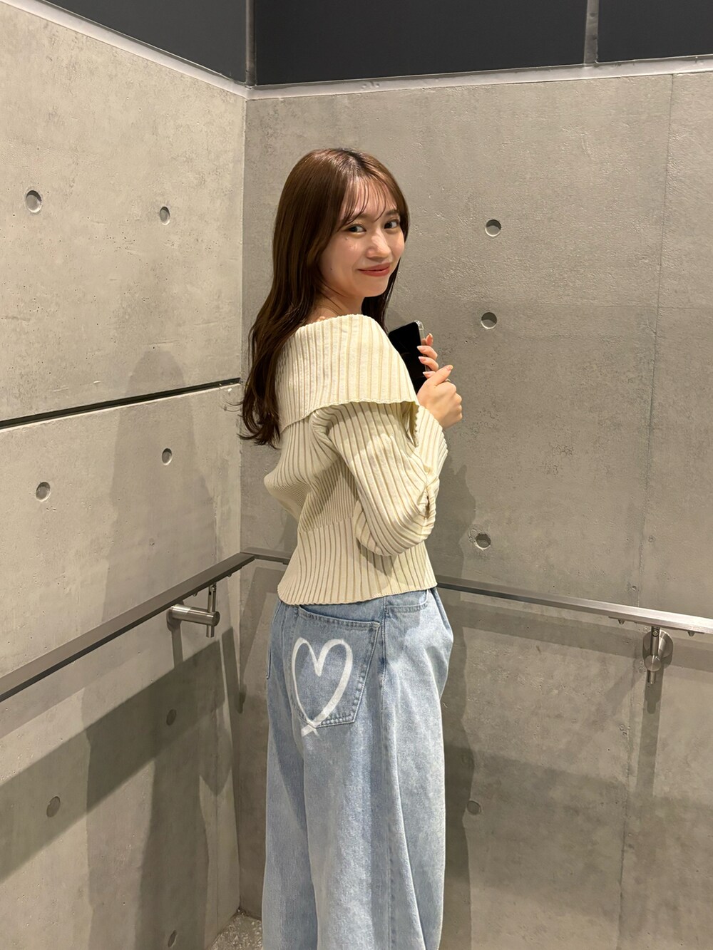 ブラック系のパンプス、ブルー系のデニムパンツ、ホワイト系のニット/セーターを着用したレディースの冬コーディネートの4枚目の写真