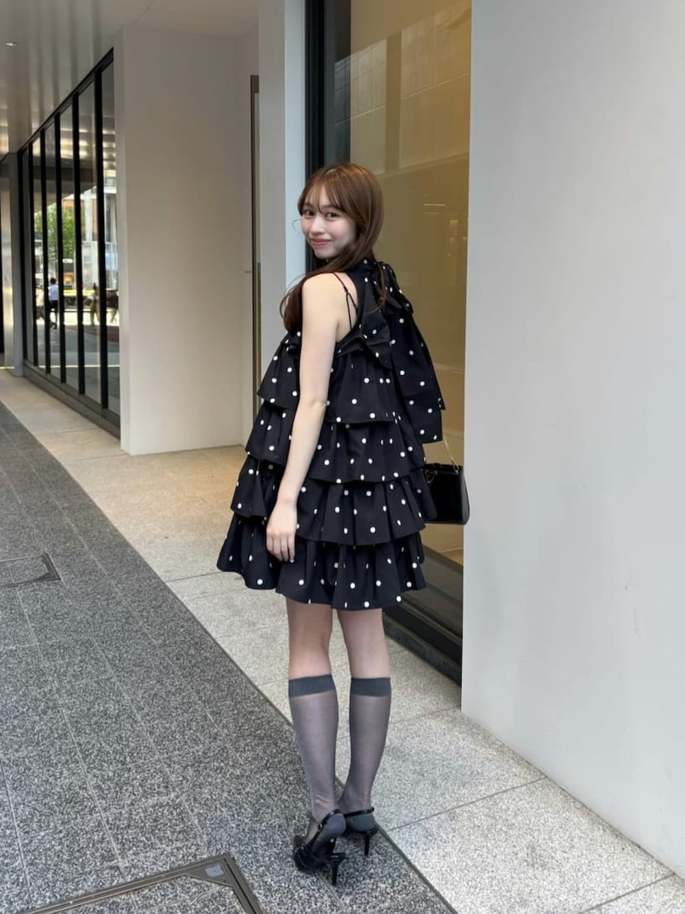 ブラック系のワンピースを着用したレディースの夏コーディネートの2枚目の写真