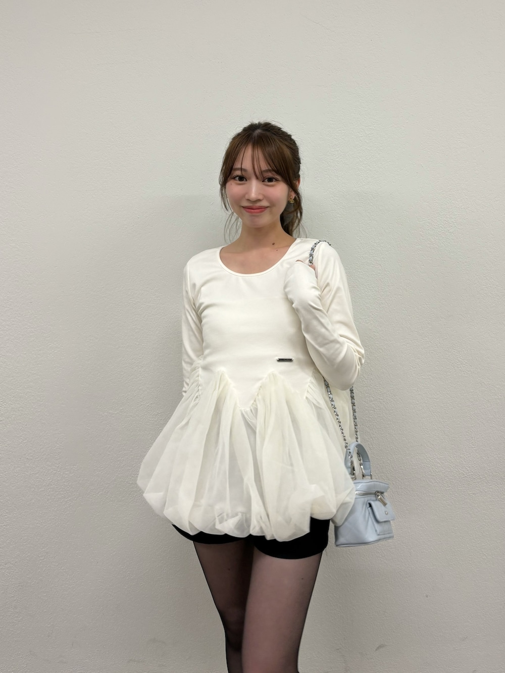 ホワイト系のTシャツ/カットソー、ブラック系のパンプス、ブルー系のショルダーバッグを着用したレディースの冬コーディネートの2枚目の写真