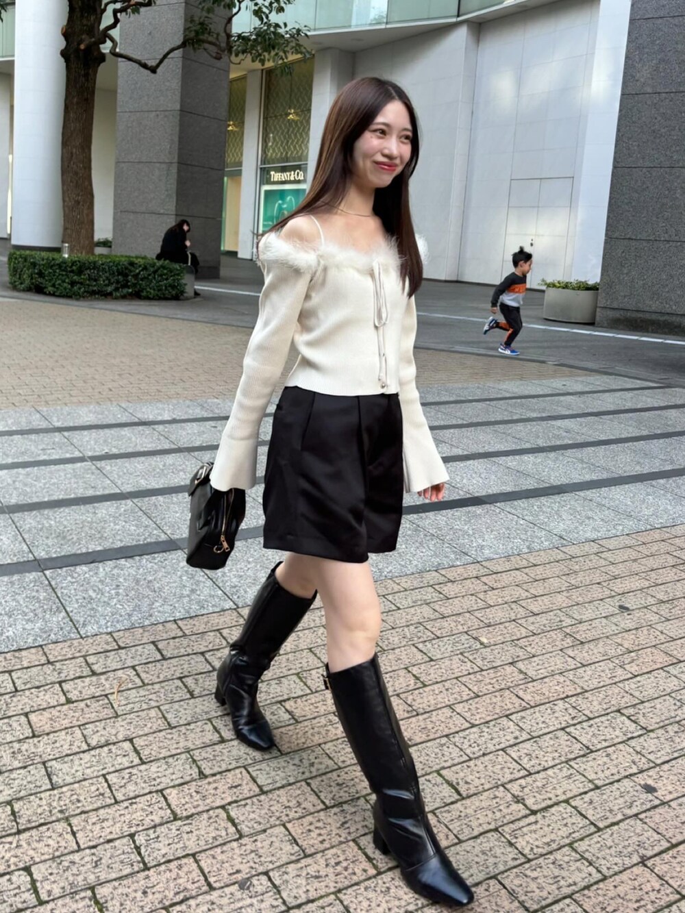 ブラック系のブーツ、ブラック系のその他パンツ、ホワイト系のニット/セーターを着用したレディースの秋コーディネートの2枚目の写真